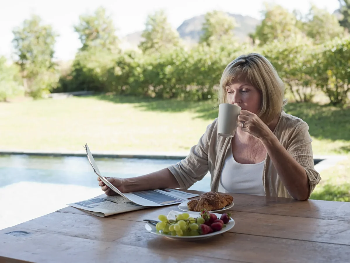 Woman reading a newsletter over coffee and breakfast