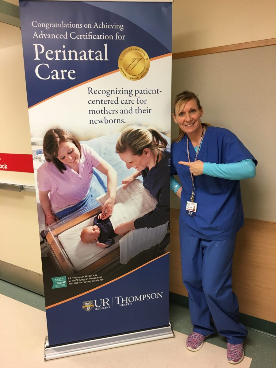 Jean Storie, RN, beside a perinatal care certification banner