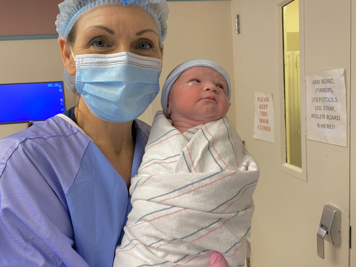 Jean Storie, RN, holding a newborn in the hospital